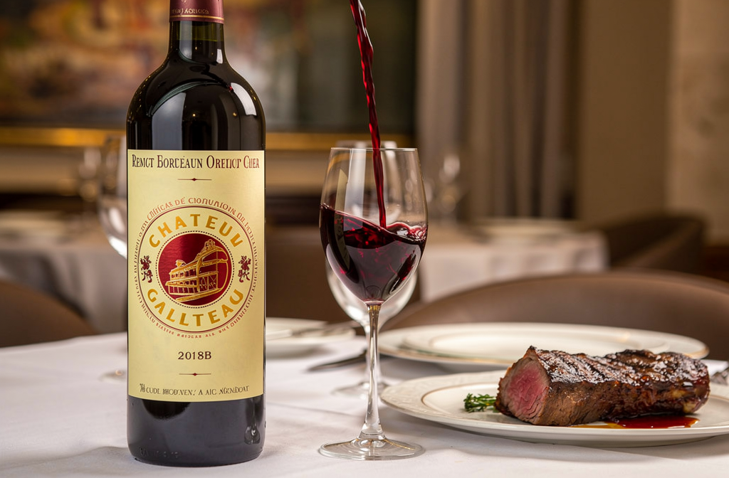 Bouteille de vin de Bordeaux servie à table avec viande grillée, illustrant les accords mets-vins.