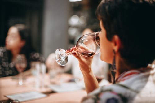 Femme dégustant du vin dans un verre, ambiance chaleureuse en cave à vin. Femme dégustant du vin dans un verre, ambiance chaleureuse en cave à vin.
